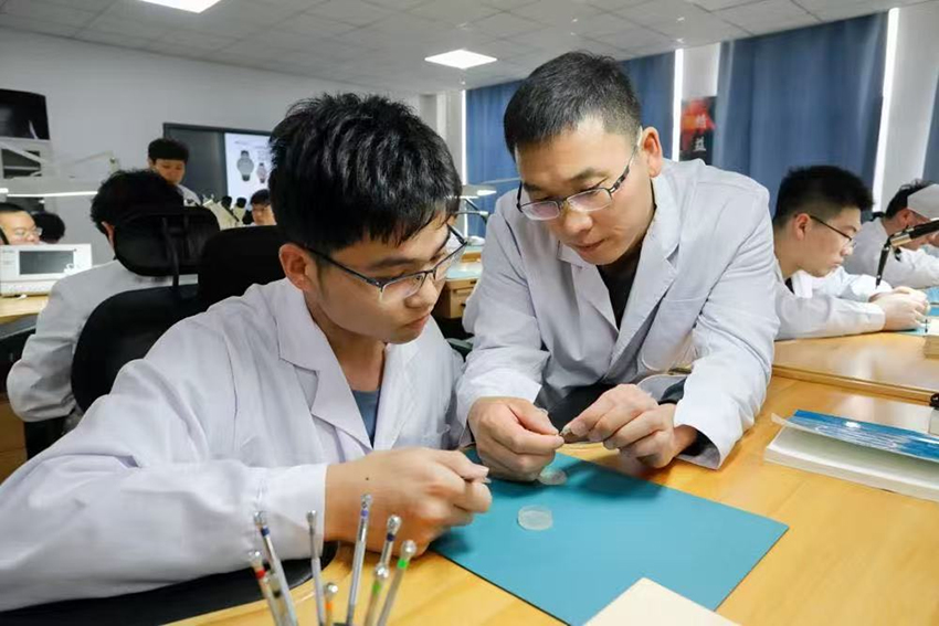 师生共同分析已装配完成的计时机芯工作状态。YABO鸭脖官网供图